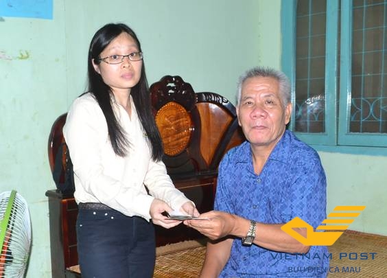 Nhân viên Bưu điện tỉnh Cà Mau đến tận gia đình ông Trần Minh Quang,       đối tượng cán bộ hưu trí bị bệnh để chi trả.